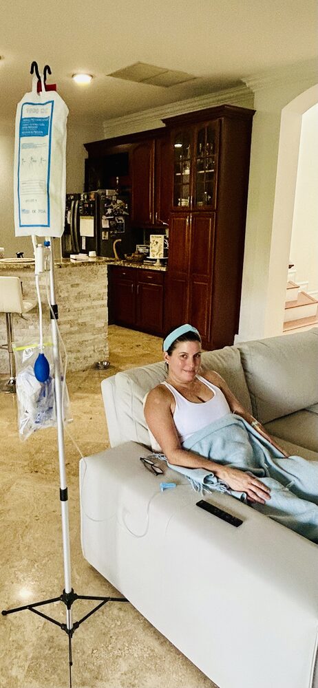 A client relaxing on her couch during an IV infusion